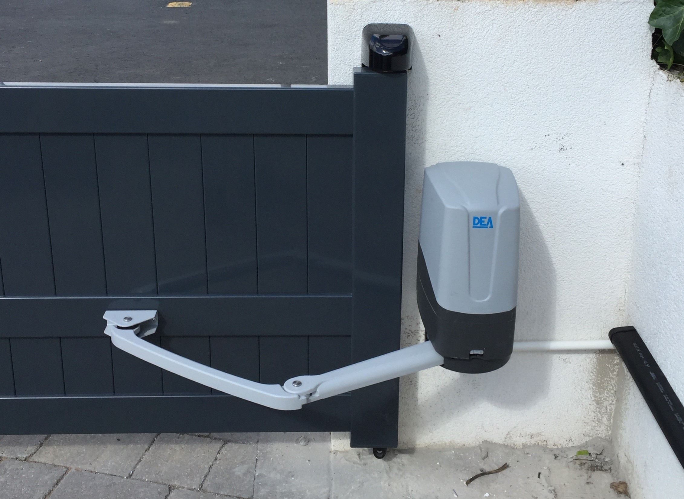 A articulated arm gate automation system on a short modern gate